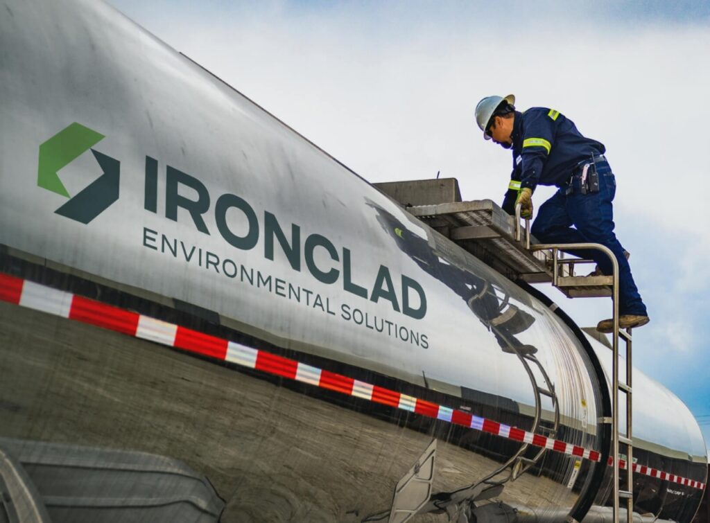 Ironclad employee preparing stainless steel tanker trailer for waste hauling project